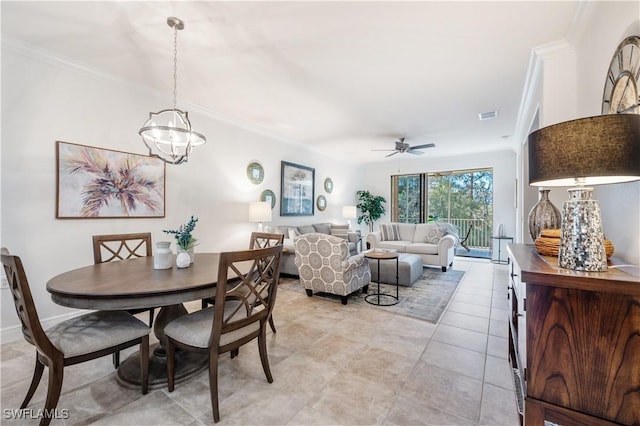 dining space featuring crown molding and ceiling fan with notable chandelier