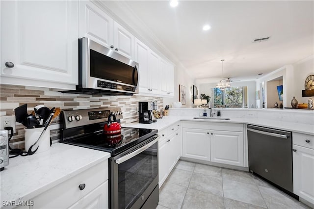 kitchen with white cabinetry, sink, light stone countertops, tasteful backsplash, and appliances with stainless steel finishes