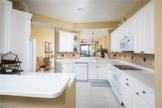 kitchen featuring kitchen peninsula, white appliances, light tile patterned floors, decorative light fixtures, and white cabinets