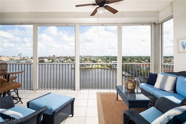 sunroom with ceiling fan, a water view, and a wealth of natural light