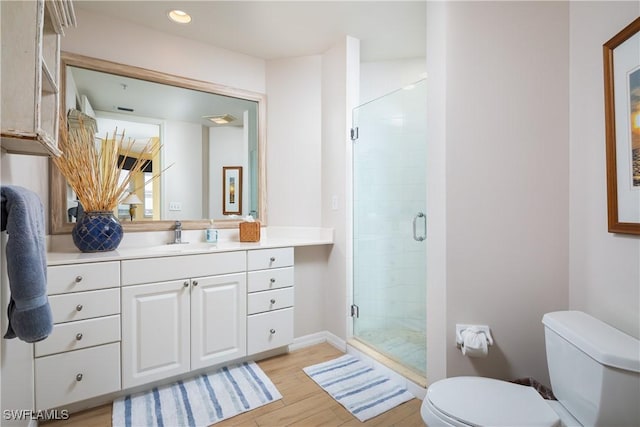 bathroom with vanity, hardwood / wood-style flooring, toilet, and walk in shower