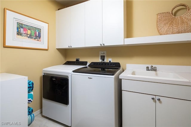 laundry area with washer and dryer, sink, light tile patterned floors, and cabinets