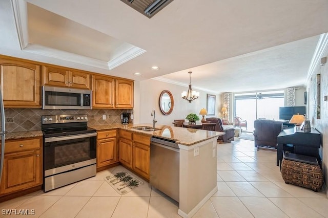 kitchen featuring appliances with stainless steel finishes, kitchen peninsula, a chandelier, and sink