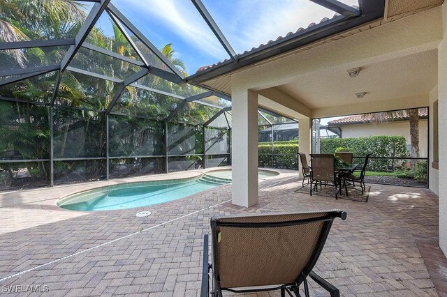 view of swimming pool featuring glass enclosure and a patio area