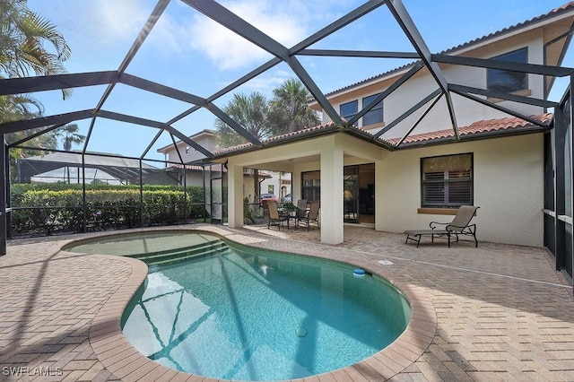 view of swimming pool with glass enclosure and a patio area