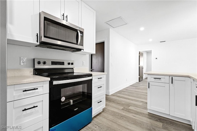 kitchen with white cabinets, electric range, and light hardwood / wood-style floors