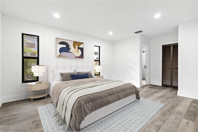 bedroom with light hardwood / wood-style floors and ensuite bath