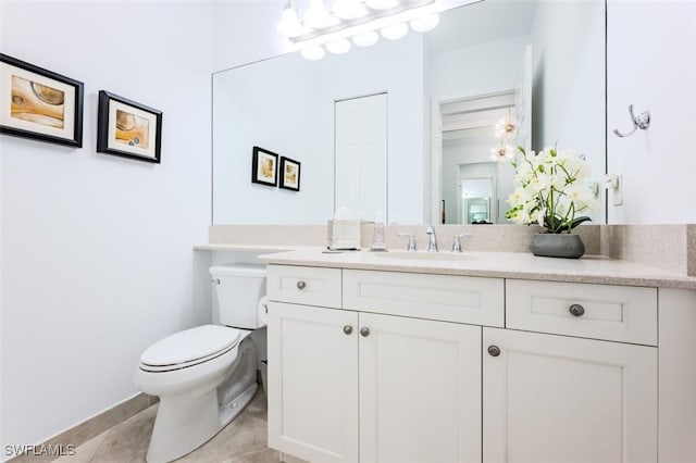 bathroom with tile patterned flooring, vanity, and toilet