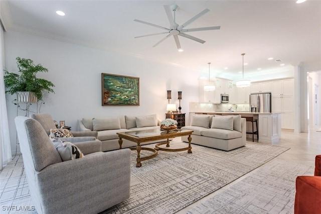 tiled living room featuring ceiling fan and ornamental molding