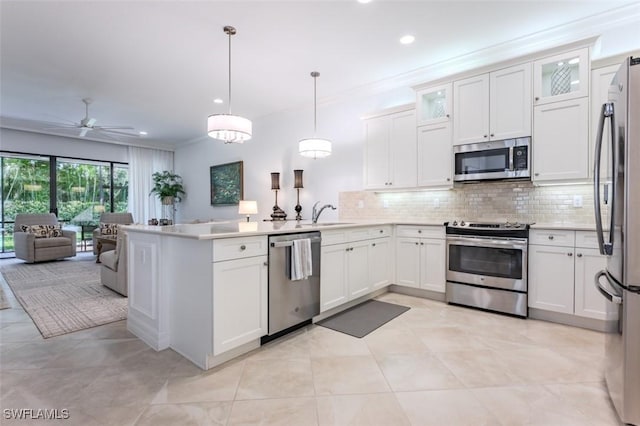 kitchen featuring appliances with stainless steel finishes, backsplash, decorative light fixtures, and white cabinetry