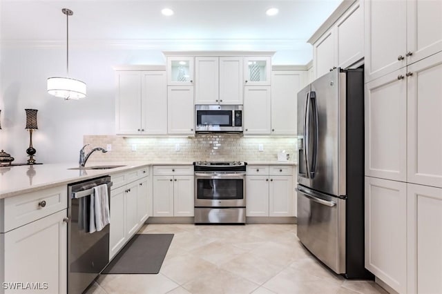 kitchen with sink, tasteful backsplash, decorative light fixtures, white cabinetry, and stainless steel appliances