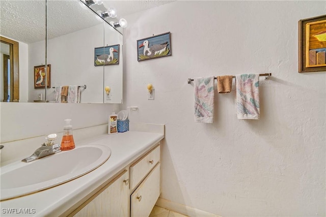 bathroom with vanity, a textured ceiling, and tile patterned floors