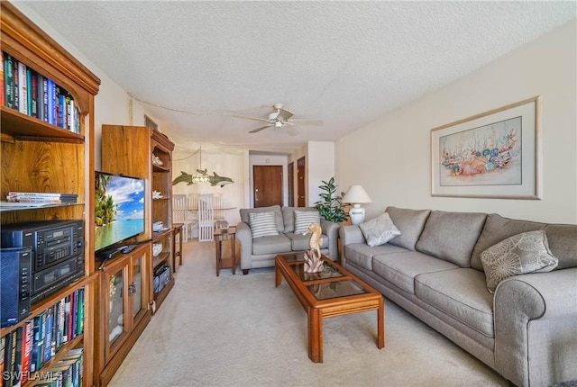 living room with a textured ceiling, light colored carpet, and ceiling fan