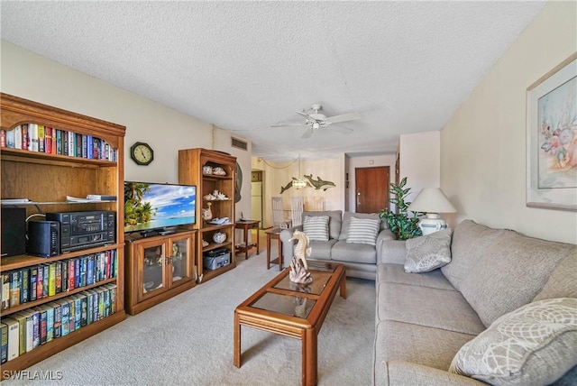 living room featuring light carpet, a textured ceiling, and ceiling fan