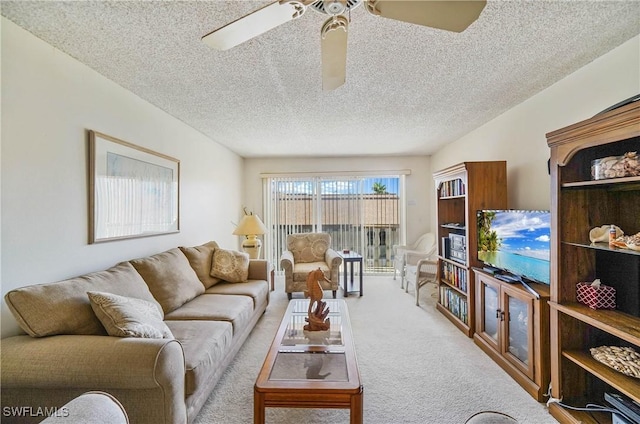 carpeted living room with ceiling fan and a textured ceiling