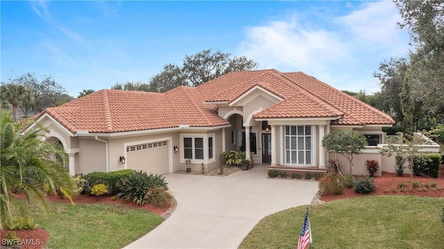 mediterranean / spanish house with a garage and a front yard