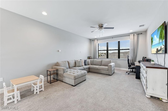 carpeted living room with ceiling fan