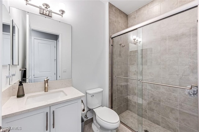 bathroom featuring toilet, vanity, and walk in shower