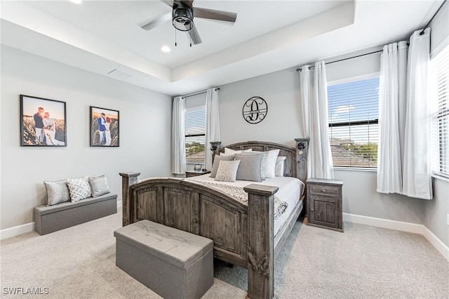 bedroom featuring a tray ceiling, ceiling fan, and light colored carpet