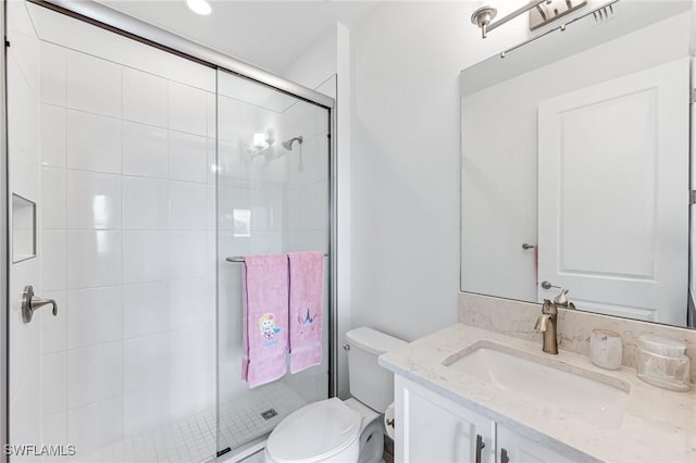 bathroom with vanity, toilet, and a shower with shower door