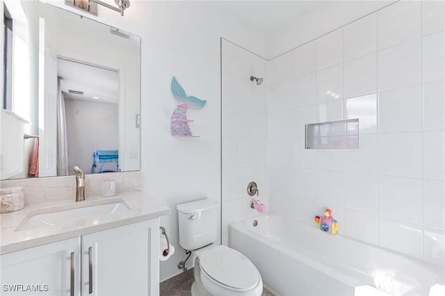 full bathroom with tiled shower / bath, vanity, and toilet