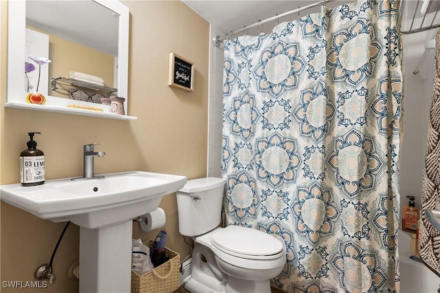 bathroom featuring shower / tub combo and toilet