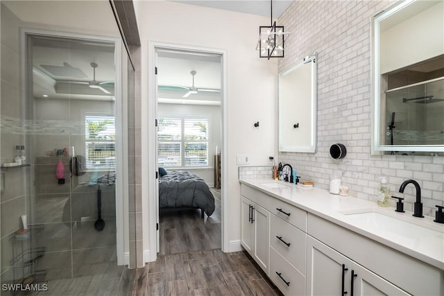 bathroom with vanity, hardwood / wood-style flooring, an enclosed shower, and backsplash