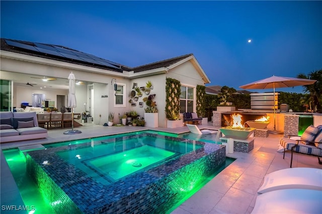 view of pool with an outdoor living space with a fireplace, a patio area, and an in ground hot tub