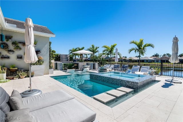 view of pool featuring a water view, an in ground hot tub, and a patio