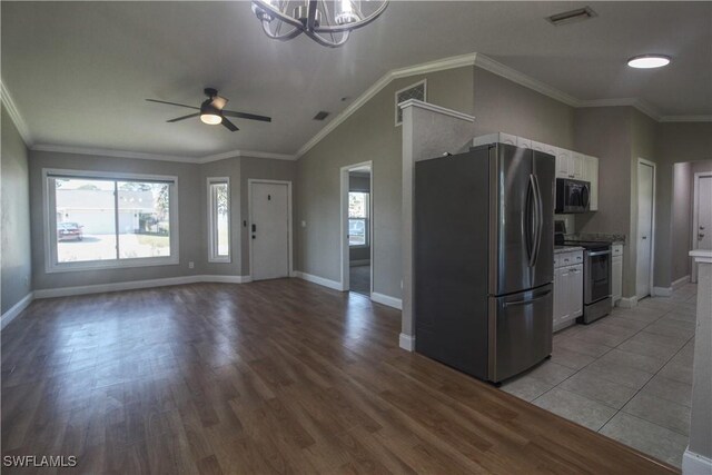 kitchen with white cabinets, a healthy amount of sunlight, ornamental molding, and stainless steel appliances