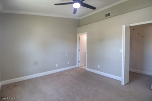 unfurnished bedroom featuring baseboards, carpet floors, visible vents, and crown molding