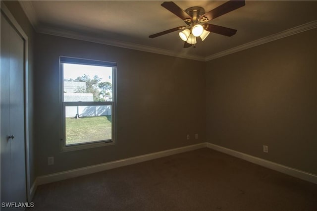 unfurnished room with baseboards, dark carpet, a ceiling fan, and ornamental molding