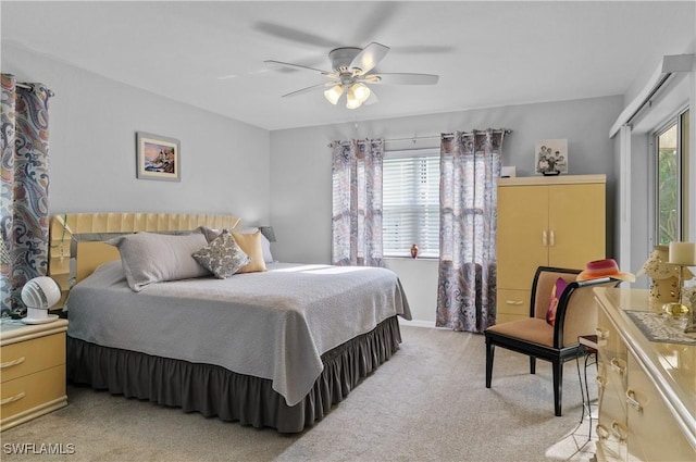 carpeted bedroom with ceiling fan and multiple windows