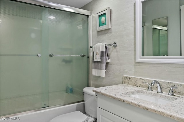 full bathroom featuring toilet, enclosed tub / shower combo, and vanity