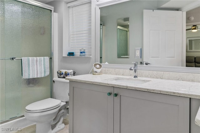 bathroom with ceiling fan, toilet, vanity, and walk in shower