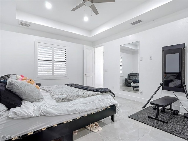 bedroom with a tray ceiling and ceiling fan