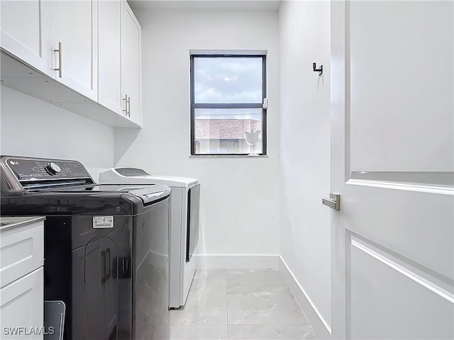 laundry area with cabinets, light tile patterned floors, and washer and dryer