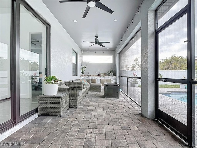 sunroom / solarium featuring ceiling fan