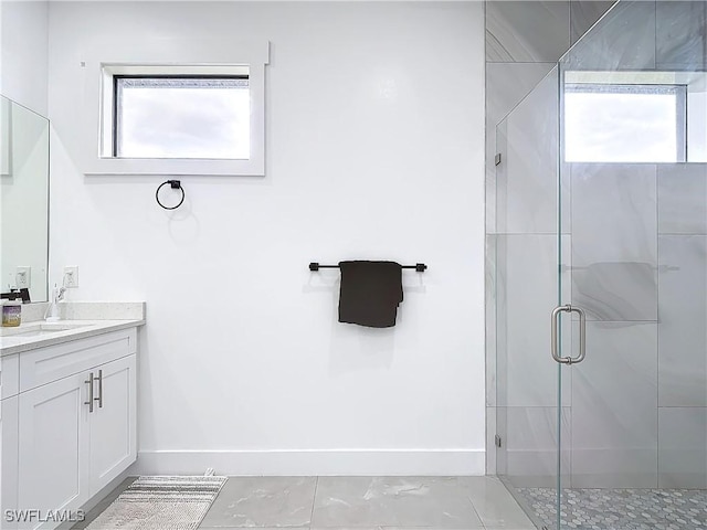 bathroom with vanity, a healthy amount of sunlight, and a shower with shower door