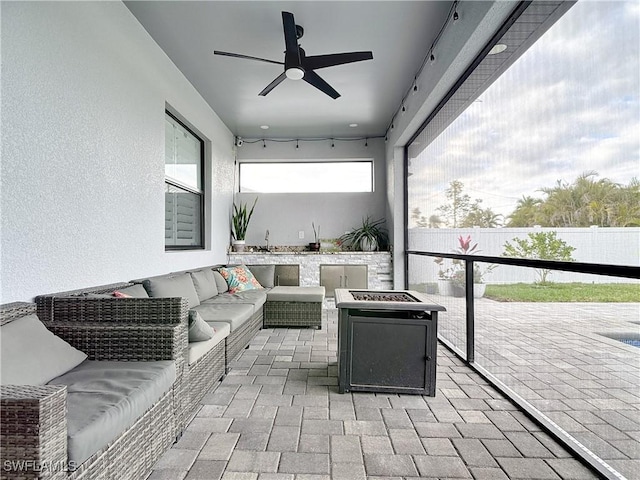 view of patio with an outdoor living space with a fire pit