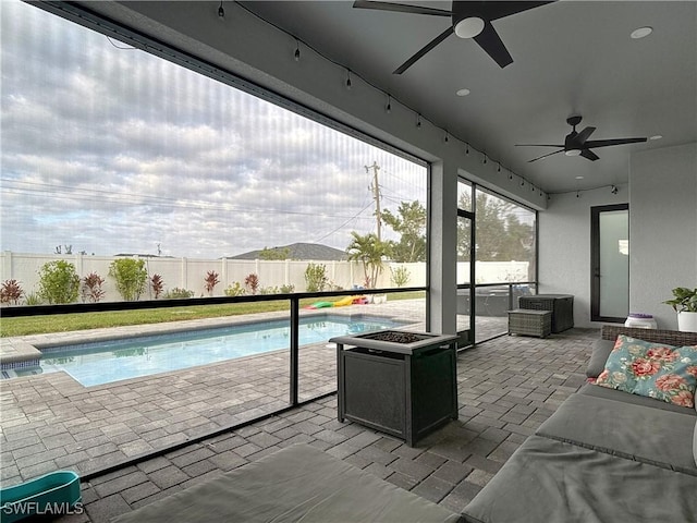 sunroom / solarium featuring ceiling fan