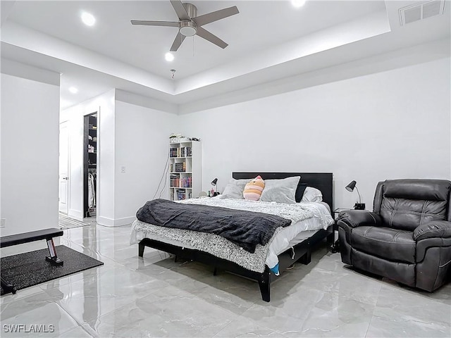 bedroom featuring a raised ceiling and ceiling fan