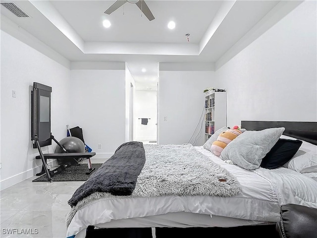 bedroom with a tray ceiling and ceiling fan