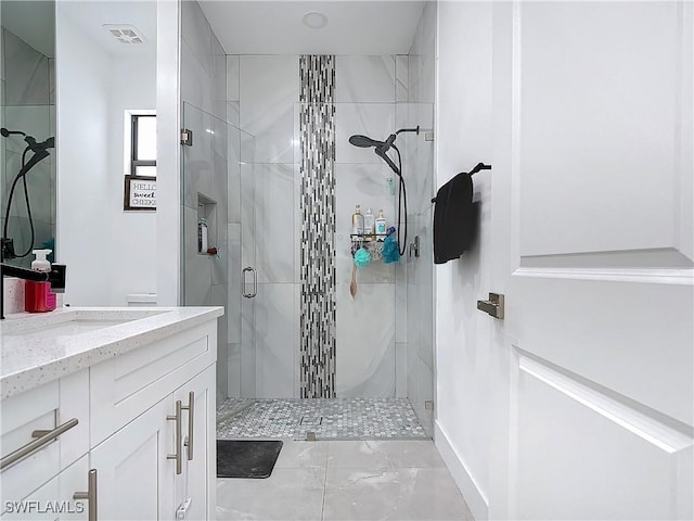 bathroom featuring a shower with door and vanity