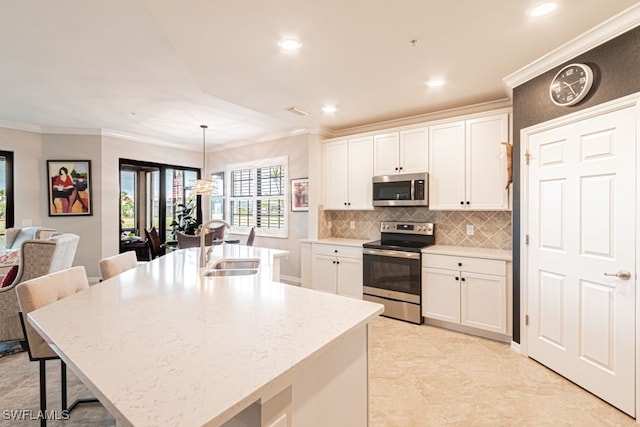 kitchen featuring pendant lighting, sink, stainless steel appliances, and an island with sink