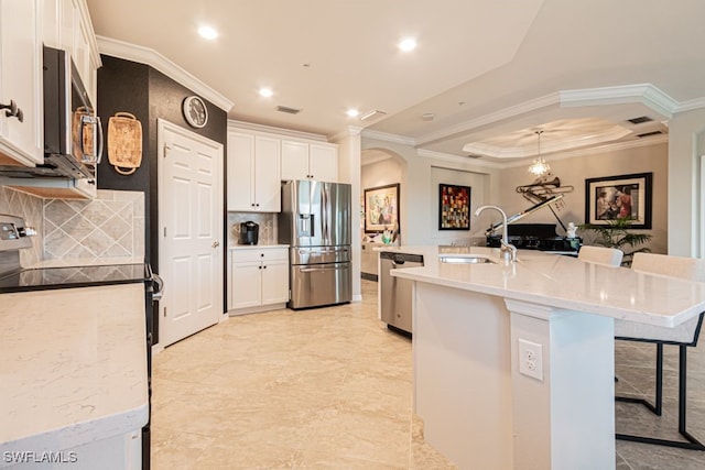 kitchen with white cabinetry, sink, a kitchen breakfast bar, a kitchen island with sink, and appliances with stainless steel finishes