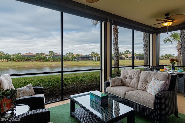 sunroom / solarium featuring ceiling fan and a water view