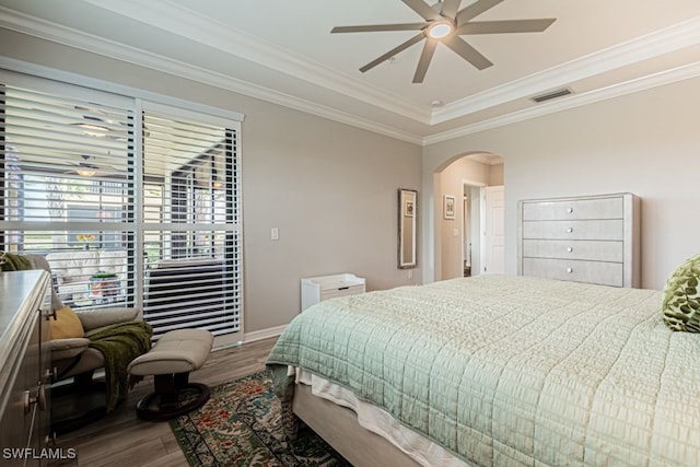 bedroom with hardwood / wood-style floors, ceiling fan, and ornamental molding