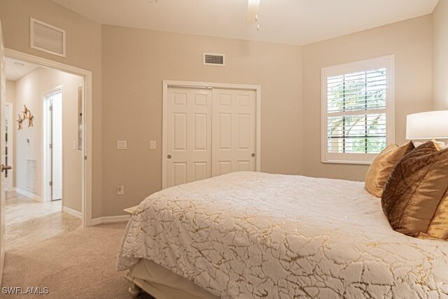 bedroom with light carpet and a closet