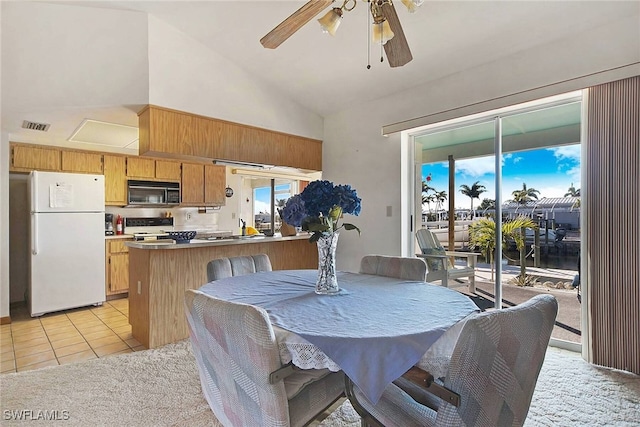 tiled dining room with ceiling fan and lofted ceiling